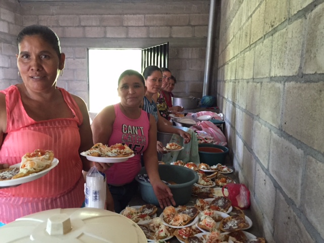 Mothers volunteer to serve up the lunch from the new kitchen.