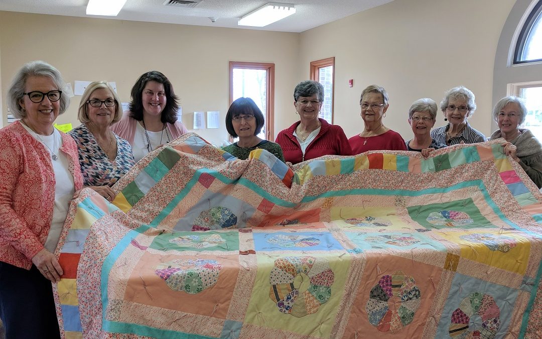 Comforters holding quilt